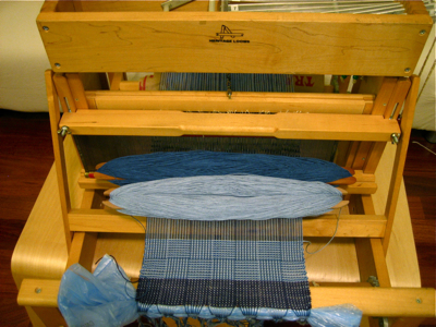 light blue and dark blue check log cabin design on the loom